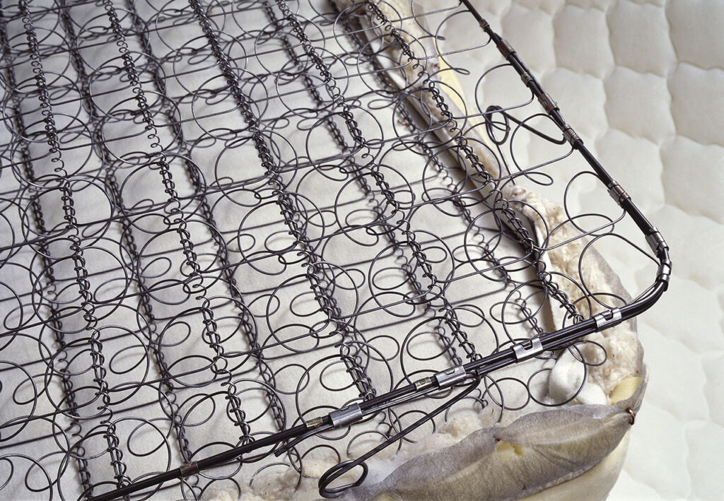 彈簧床。這張床墊是一條鋼絲卷製的連續彈簧組成的連結式彈簧床
