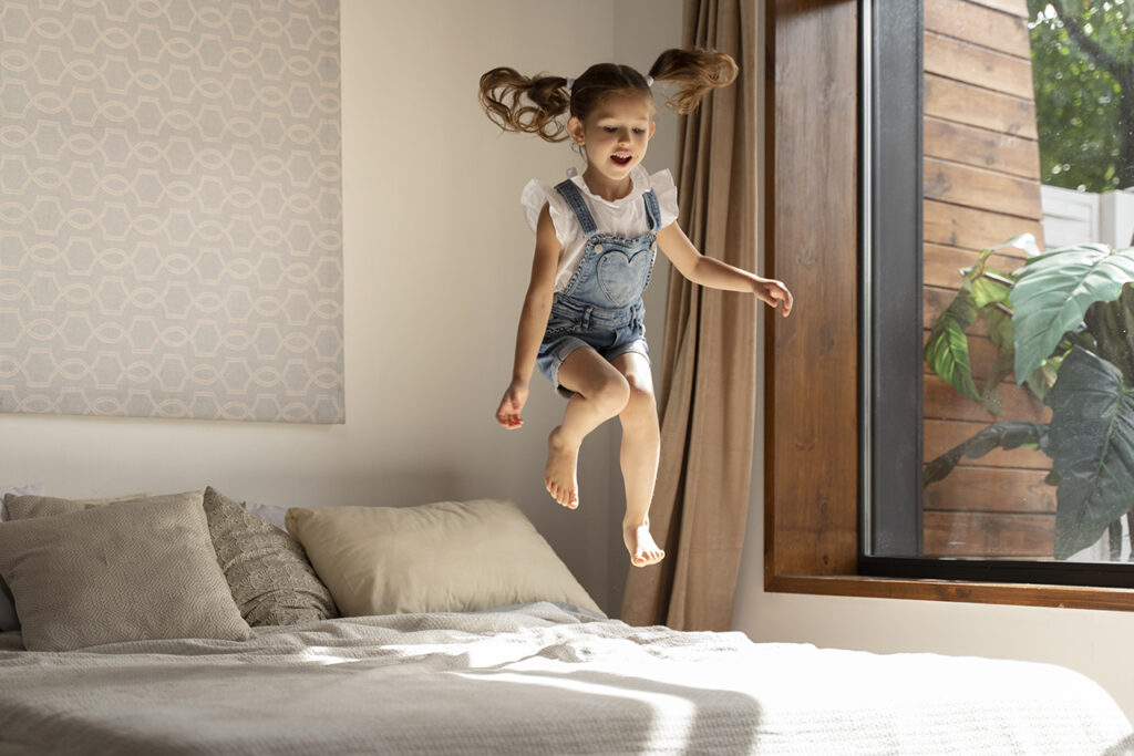 小孩在床上跳得很高，這是床墊的彈力。體重與重力加速度讓施加在床墊表面的重力比平躺時大很多，因此產生的彈力讓跳躍更高